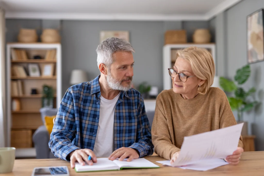 Elderly couple reviewing documents at home.